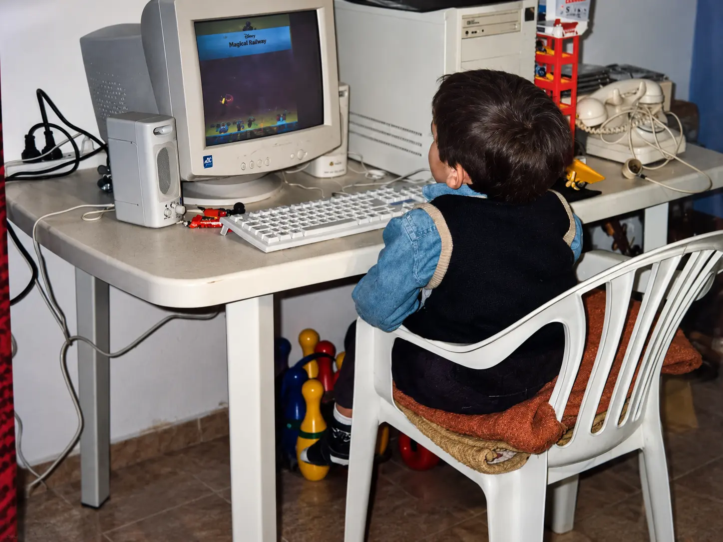 Juan Cruz as a kid, seen from behind, playing a Disney game on a beige PC.